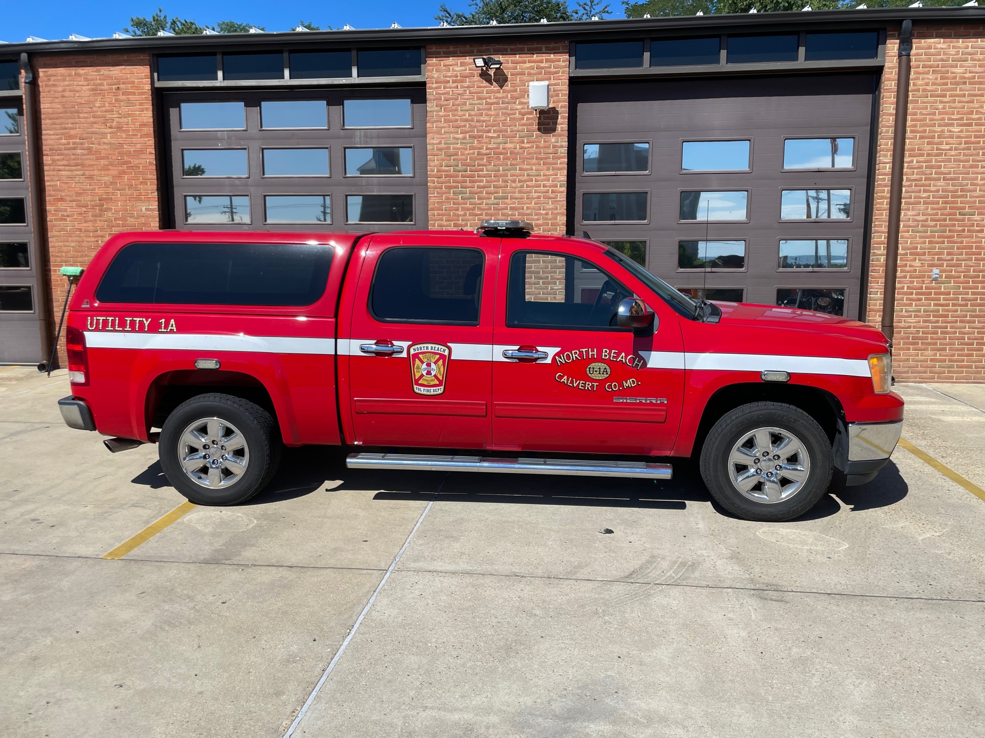 Utility 1A in front of a brick firehouse